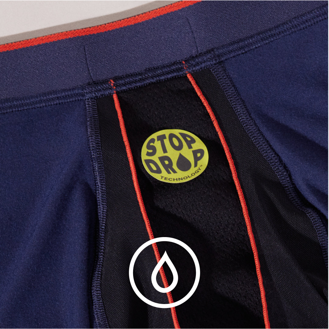 Closeup on the interior front panel on navy blue SAXX Boxer Briefs with green sticker icon for Stop Drop Technology™.