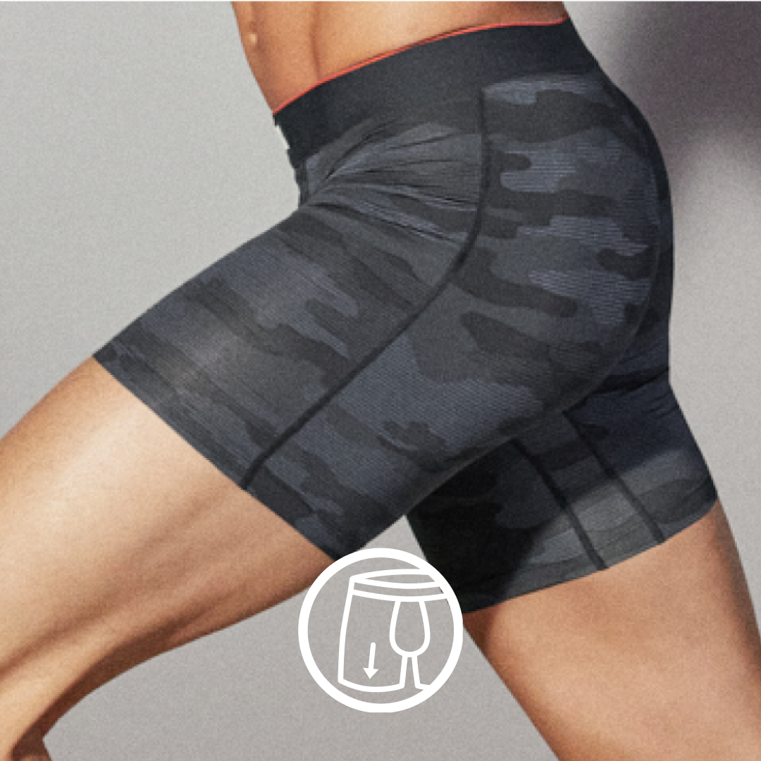 Closeup on side view of man mid-stride in black and grey camo print SAXX Boxer Briefs. White icon indicates No-RideUp Leg™.