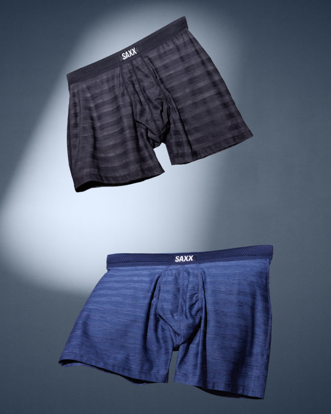 Two pairs of striped boxer briefs floating against a dark grey background. Bothe pairs are striped, one is black, one is blue.