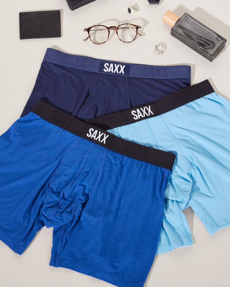 Three pairs of boxer briefs arranged in a triangle formation on top of each other. They are each a different shade of blue