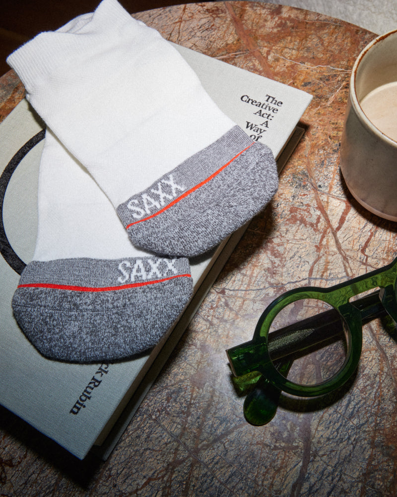 A pair of white socks with grey toe sections on top of a map
