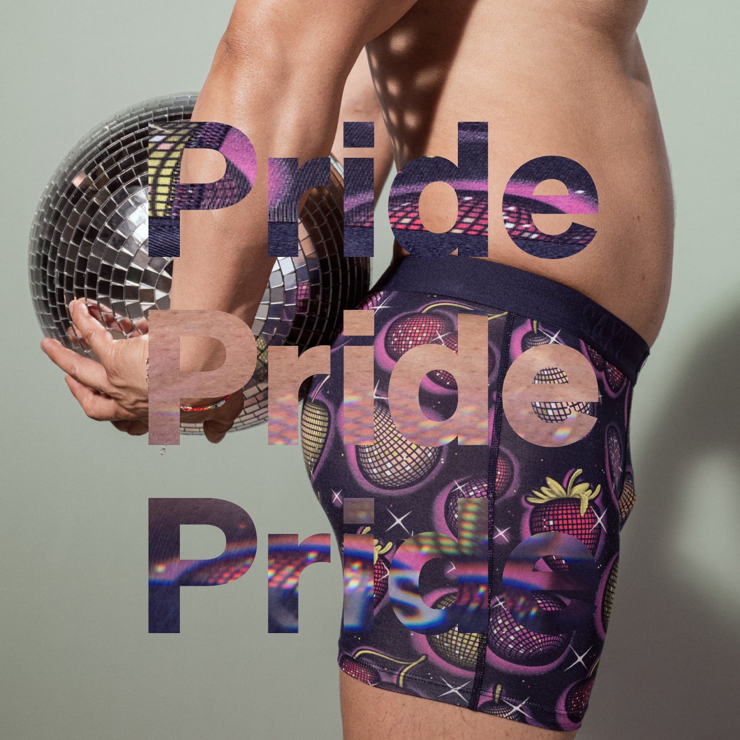 An image of a mans body wearing printed underwear with a disco ball tucked between his arm and body.