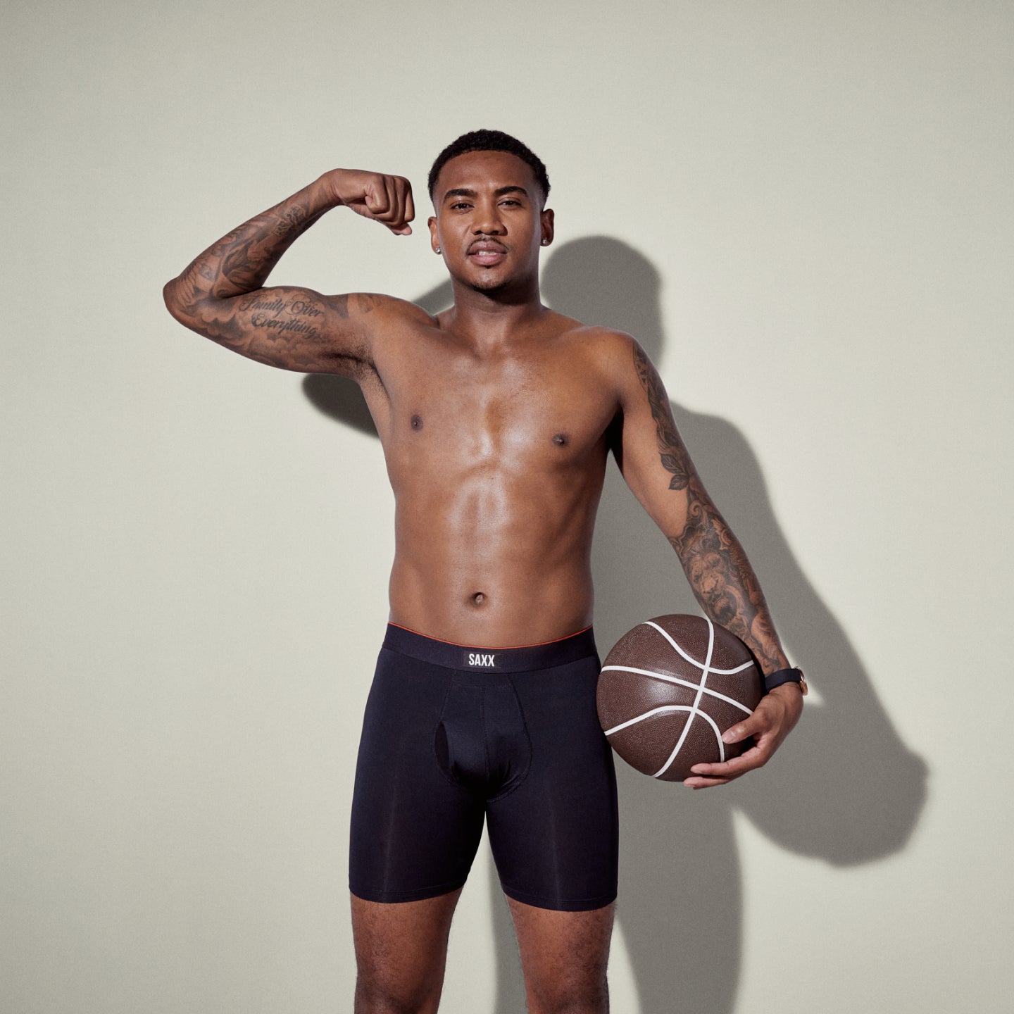 A Man flexing while holding a basketball, wearing SAXX Multi-Sport Mesh Boxer Brief