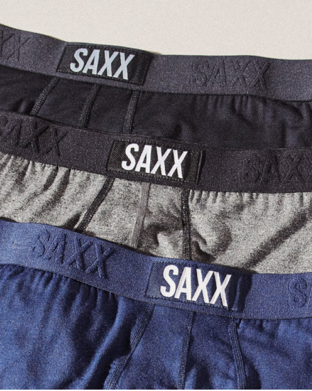 The waistbands of three pairs of boxer briefs laid one on top of each other. 