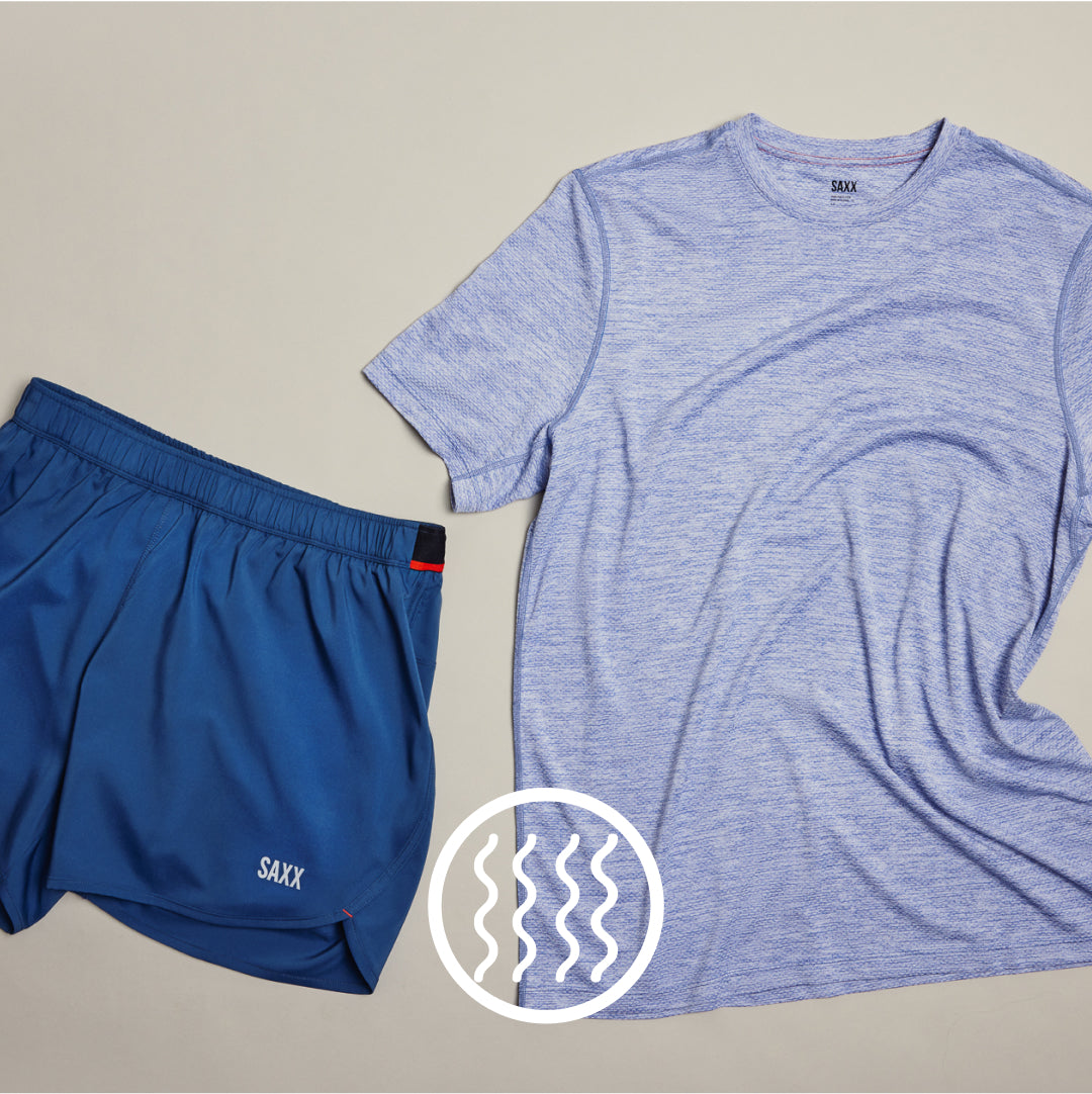 Blue SAXX tee and blue SAXX 2N1 Shorts laid flat over neutral background. White icon indicates odor-resistant.