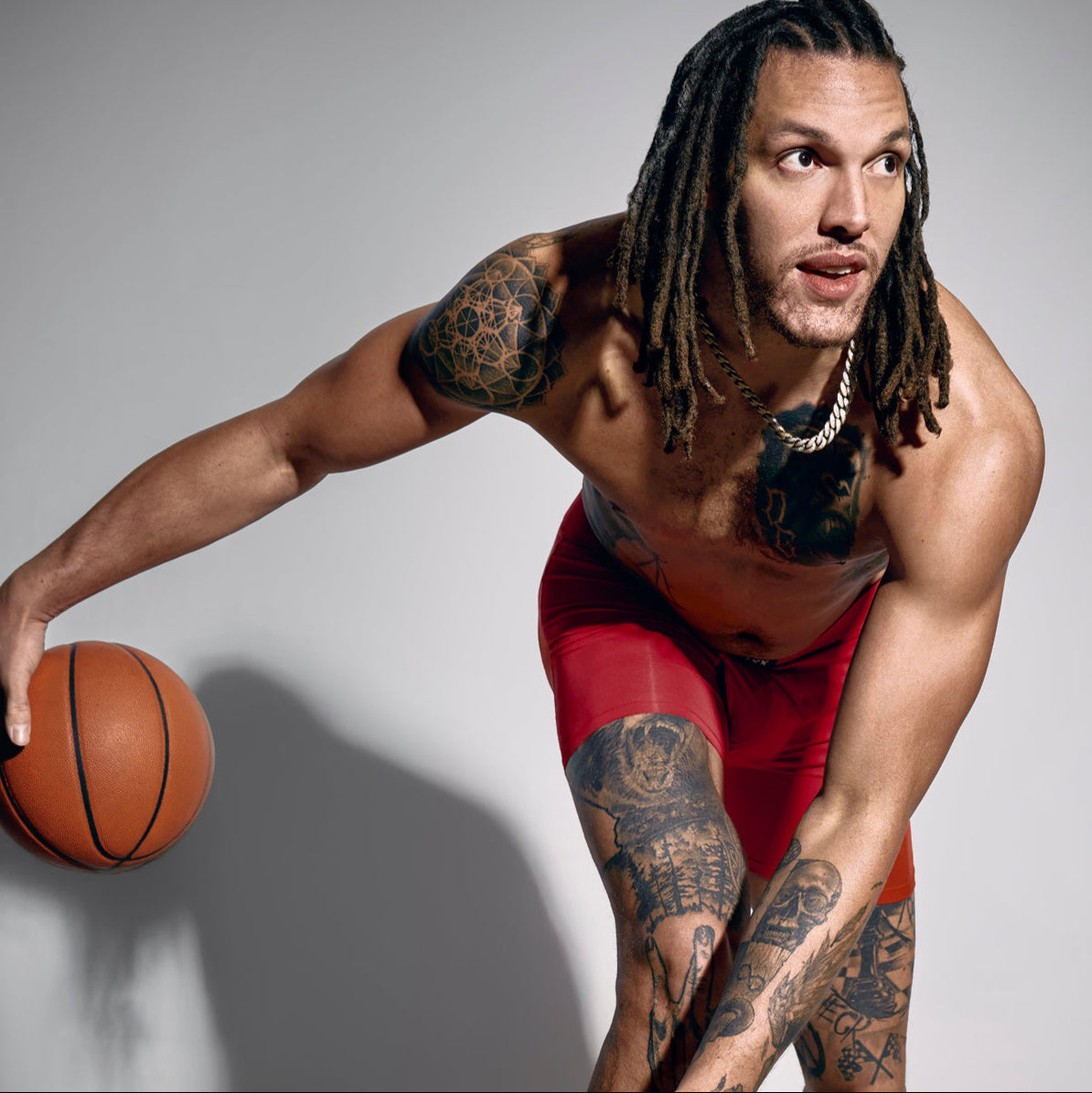 SAXX Gamechanger and Pro Basketball player Aaron Gordon holding a basketball wearing only the Multi-Sport Mesh Boxer Brief.