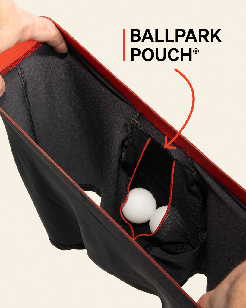 An interior photograph of a pair of boxer briefs with a pouch containing two ping pong balls.