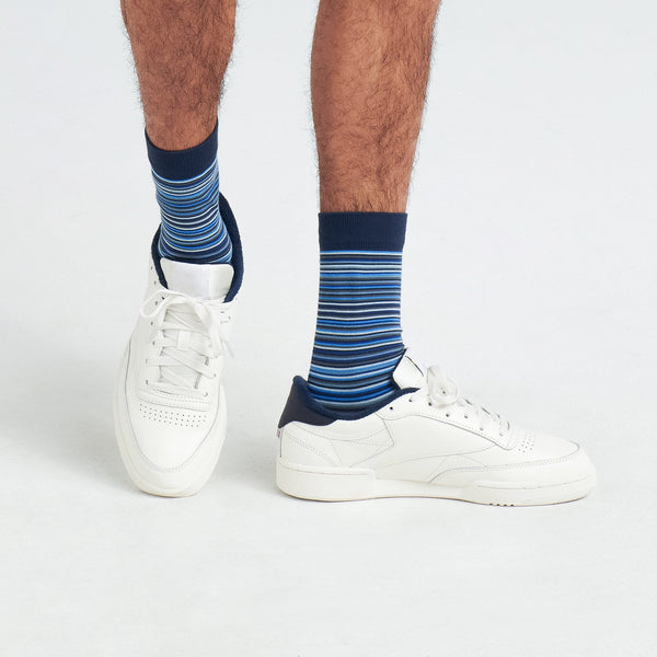 Side - Model wearing Whole Package Crew Sock in Vibrant Stripe- Navy