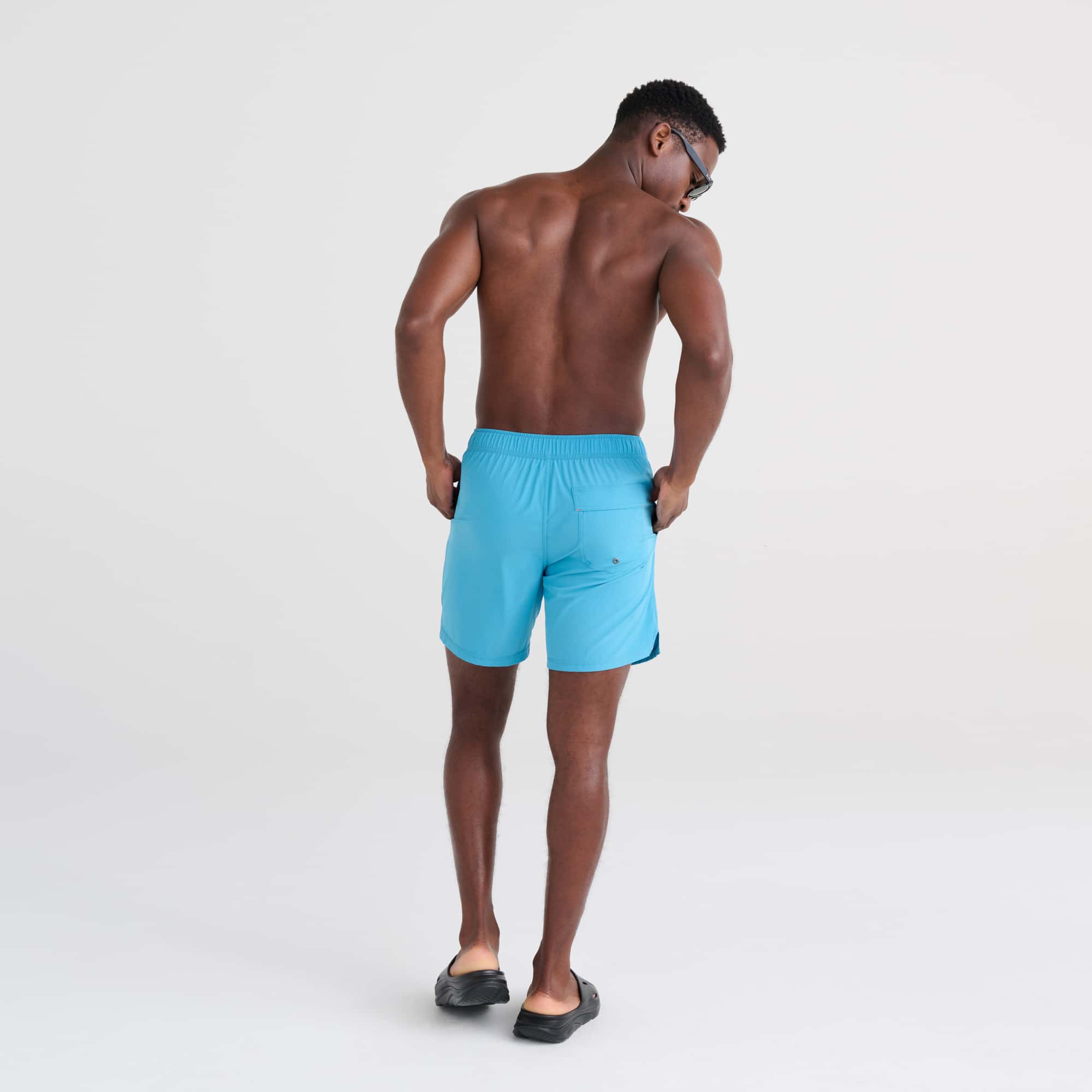 Back - Model wearing Oh Buoy 2N1 Swim Trunk 7" in Blue Moon